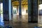 A tunnel of pillars under a freeway overpass with brown rushing river water with graffiti on the pillars at the Chattahoochee Rive