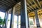 A tunnel of pillars under a freeway overpass with brown rushing river water with graffiti on the pillars at the Chattahoochee Rive