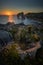 Tunning Suset with rocks fuly of vegetation and an arch rock formation. Asturias, Spain