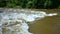 Turbulent gushing river water, vertiginous flow, swirling foamy water waves after heavy rain, turbid water rapids of Mur river,