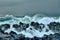 turbulent waves of Pacific ocean and rugged beauty of basalt rocks