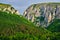 Turda Gorge Cheile Turzii entrance with massive, tall, rock walls, early in the morning, with sunrise light and green forest