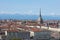 Turin rooftops, Mole Antonelliana tower and mountains in a sunny day in Italy