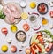 Turkey breast On a cutting board with herbs different fruits and vegetables Cucumbers mushrooms tomato salad pepper lemon in a