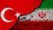 Turkey and Iran conflict, war concept. Flags background, cracked and damaged concrete wall