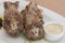 Turkey necks,  served with horseradish puree,  placed on white plate,  light background,  isolated