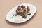 Turkey necks,  served with horseradish puree,  placed on white plate,  light background,  isolated