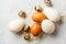 Turkey, quail and chicken eggs on hay on gray background, top view
