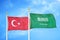 Turkey and Saudi Arabia two flags on flagpoles and blue cloudy sky