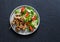 Turkey skewers and vegetables fresh salad on a dark background, top view