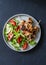 Turkey skewers and vegetables fresh salad on a dark background, top view