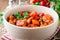 Turkey stew with bell peppers, green beans and tomatoes in bowl on dark wooden table