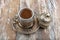 Turkish coffee in traditional silver cup on white wooden table