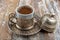 Turkish coffee in traditional silver cup on white wooden table