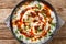 Turkish eggs with garlic yogurt and spicy butter dressing close-up in a plate. horizontal top view