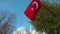 Turkish flag on background of mosque. Action. Turkish flag is flying in square near mosque. Travel around capital of