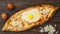 Turkish flatbread pide with egg and cheese. Top view