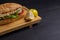 Turkish food sandwich balik Ekmek with grilled mackerel, tomatoes, onions and lettuce served with lemon closeup on the table.
