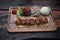 Turkish lamb sis kebab with rice and vegetables on rustic wooden table