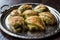 Turkish Midye Baklava Mussel Shape Baklawa with green pistachio Powder and Butter Cream in Silver Tray.