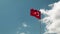 Turkish national flag waving in wind. Red flag with moon and heart shape waving on pipe against blue cloudy sky. Flag of republic