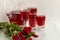 Turkish Red Rose Sherbet in crystal glasses on white surface with fresh red roses