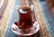 Turkish tea in traditional glass cup on handmade ornamental tablecloth Turkey