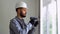 Turkish workman in uniform installing or adjusting plastic windows in the living room at home