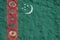 Turkmenistan flag depicted in bright paint colors on old relief plastering wall. Textured banner on rough background