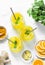 Turmeric, ginger, orange lemonade. Summer cold drink on light background, top view