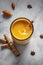 Turmeric latte in a glass with turmeric powder and cinnamon sticks