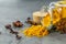 Turmeric powder in glass bottle, anise stars and dry flowers of turmeric on the table closeup. Anti-inflammatory remedies,