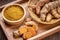 Turmeric Powder and Turmeric root in wooden plate, Curry Powder on a wooden table background