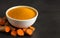 Turmeric powder in a white bowl and fresh turmeric curcumin on black background,copy space,spices