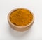 Turmeric powder in a wooden bowl or fresh curcuma