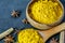 Turmeric powder in wooden spoon and bowl, cinnamon and anise stars on the dark background closeup. Healing spice, alternative