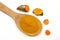 Turmeric powder in a wooden spoon and isolated turmeric roots on a white background. Turmeric helps reduce fat.