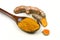 Turmeric powder in a wooden spoon and isolated turmeric roots on a white background. Turmeric helps reduce fat.