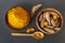 Turmeric roots and powder on gray slate background, overhead shot