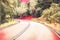 Turn on empty forest road. Summer travel landscape blurry digital illustration.