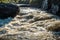 A turn on a mountain river, rushing water with spray and foam, big rocks