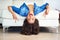 Turn your frown upside down. a young woman showing the peace sign while lying upside down on her sofa.