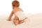 Turned away baby plays on bed isolated over white background