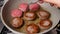 Turning Beef patties in the frying pan close up