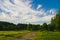 Turning country road against scenic clouds