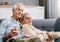 Turning home into their very own cinema. Shot of a happy mature couple relaxing together with wine and popcorn on the