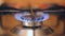 Turning on the kitchen gas stove, natural gas ignites the fire in blue and a cauldron is put on the fire