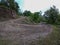 Turning point of a rocky hilly mud road in a forest at evening time