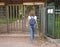 Turnstile, restricted entry. A lady travels through a turnstile to a private Park.