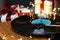 Turntable with vinyl record, fairy lights and Christmas gift boxes, closeup